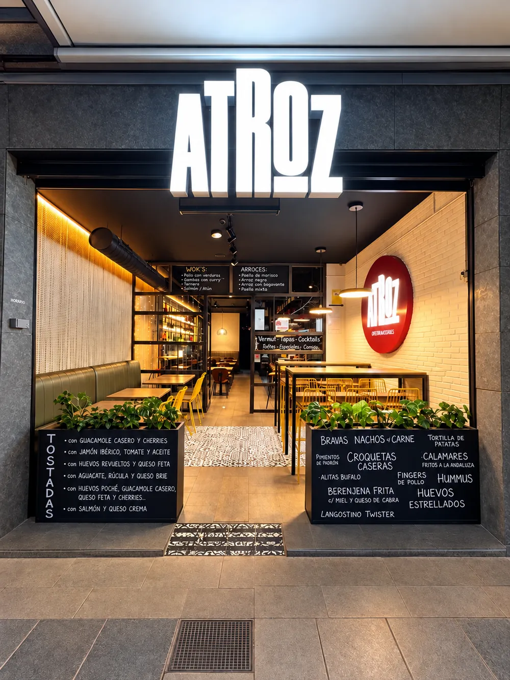 Fachada de ATROZ Castelldefels con el rótulo iluminado